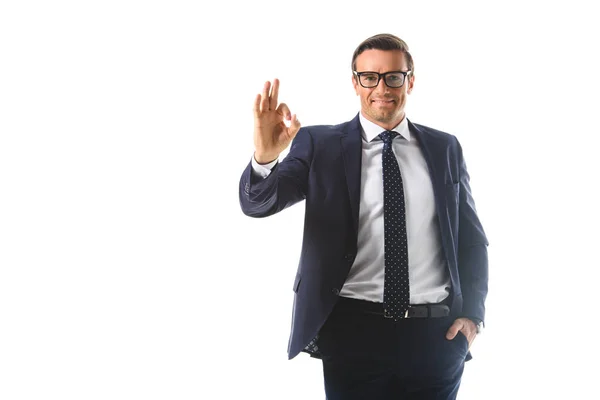Улыбающийся бизнесмен в очках, показывающий жест в порядке, изолированный на белом фоне — стоковое фото