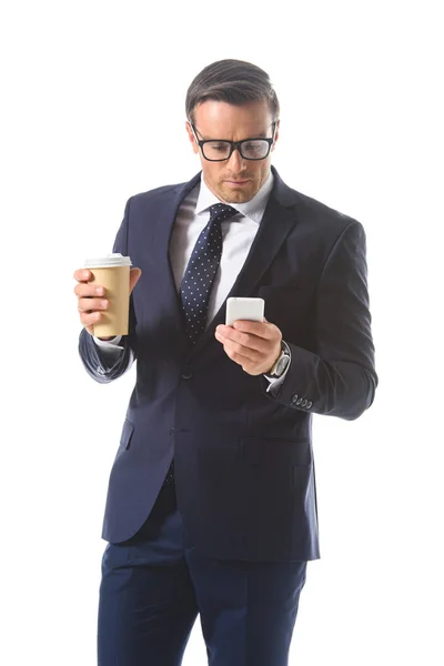 Geschäftsmann mit Brille prüft Smartphone und hält Papiertasse Kaffee isoliert auf weißem Hintergrund — Stockfoto