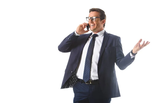 Smiling businessman in eyeglasses talking on smartphone and gesturing by hand isolated on white background — Stock Photo