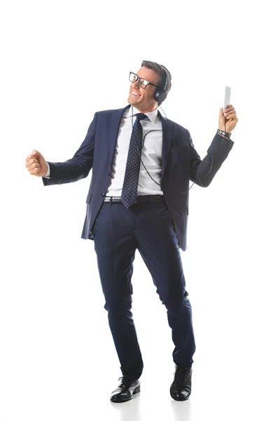 Felice uomo d'affari in occhiali ascoltare musica in cuffia con smartphone e gesticolare a mano isolato su sfondo bianco — Foto stock