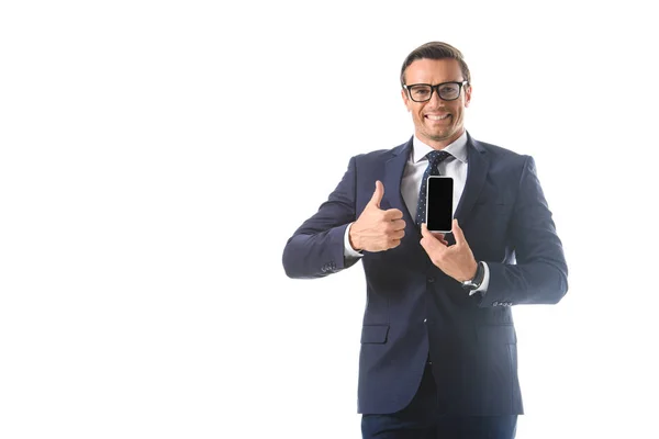 Hombre de negocios sosteniendo teléfono inteligente con pantalla en blanco y haciendo gesto de pulgar hacia arriba aislado sobre fondo blanco - foto de stock