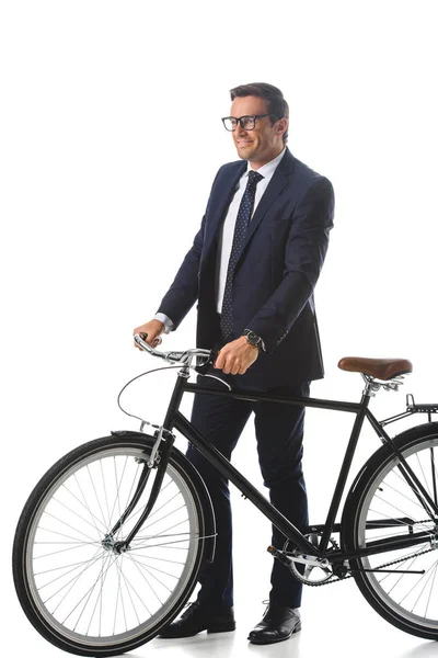 Smiling businessman in eyeglasses standing with bicycle isolated on white background — Stock Photo