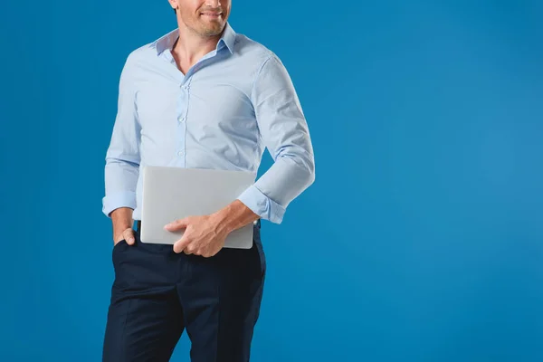 Cropped shot of smiling man holding laptop isolated on blue — Stock Photo