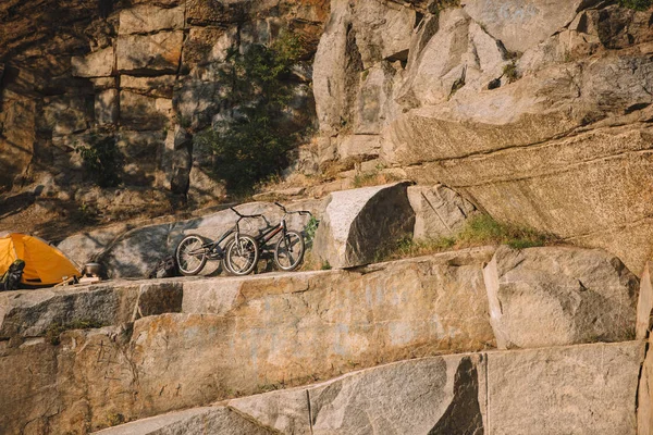 Vista panorâmica de bicicletas de montanha perto de tenda de viagem em penhasco rochoso — Fotografia de Stock