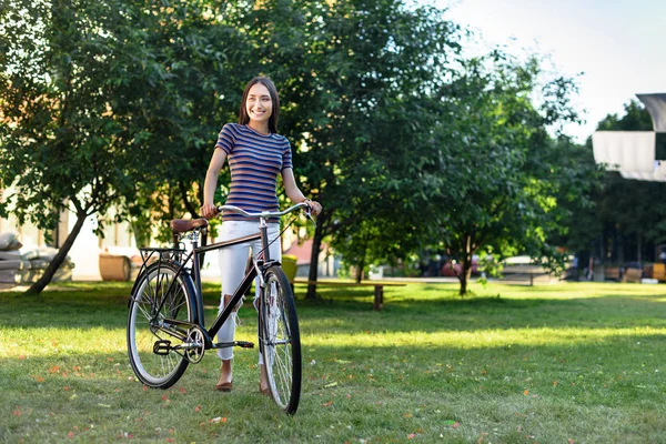 Молода азіатка з ретро-велосипедом в парку — стокове фото