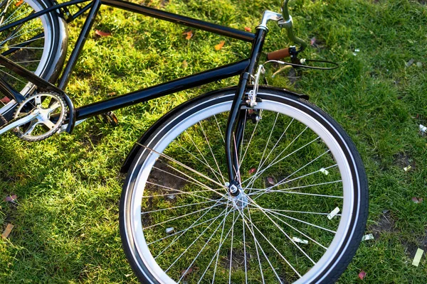 Close up vista da bicicleta retro deitado na grama verde no parque — Fotografia de Stock