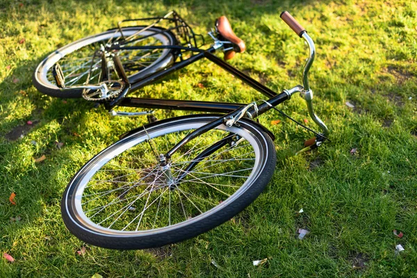 Vue rapprochée du vélo rétro couché sur l'herbe verte dans le parc — Photo de stock