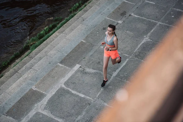 Vista aérea de la joven deportista corriendo en la ciudad - foto de stock