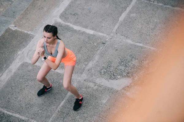 Vista aérea de la joven deportista sentada en la ciudad - foto de stock