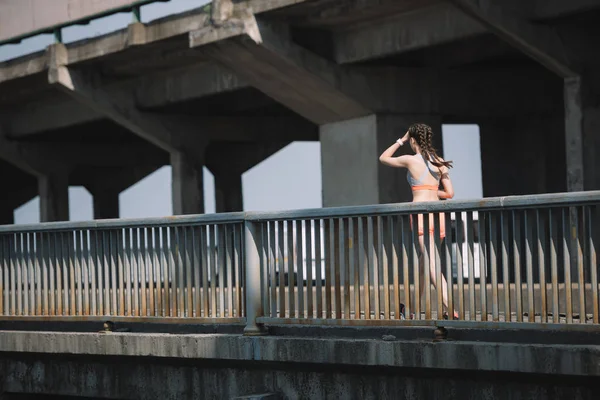 Jeune jogger courir sur le pont en ville — Photo de stock
