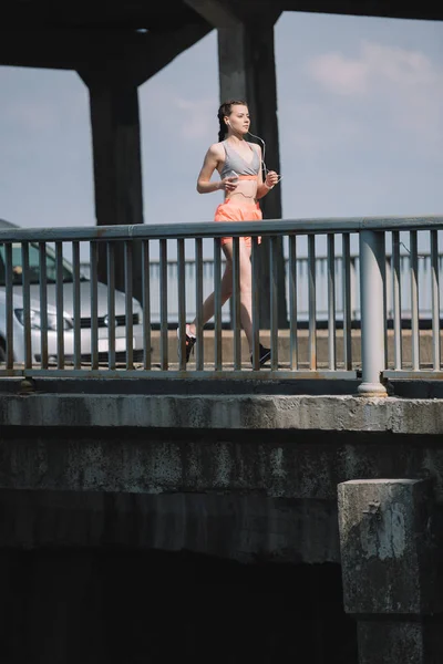 Sportlerin läuft auf Brücke in der Stadt — Stockfoto