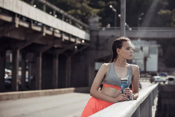 Приваблива спортсменка тримає спортивну пляшку з водою в місті — стокове фото