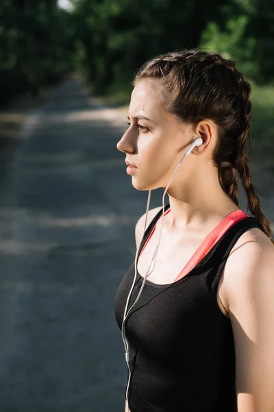 Athletic girl listening music with earphones — Stock Photo