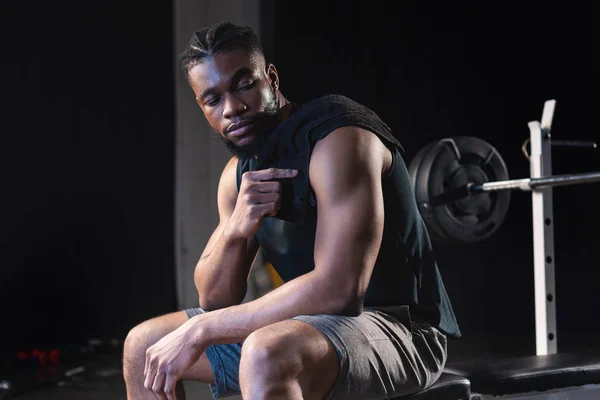 Sportivo afroamericano con asciugamano sulla spalla seduto dopo l'allenamento in palestra — Foto stock
