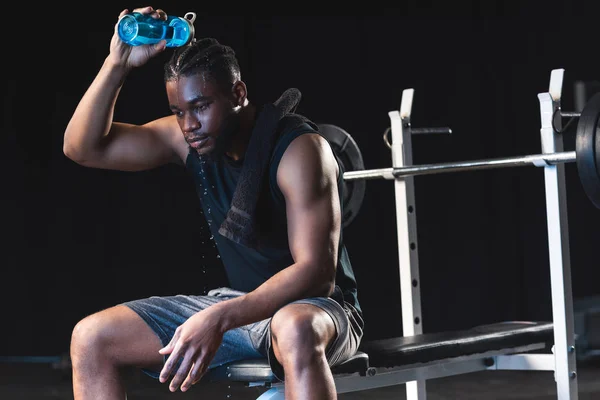 Sportif afro-américain transpirant versant de l'eau sur la tête après l'entraînement au gymnase — Photo de stock