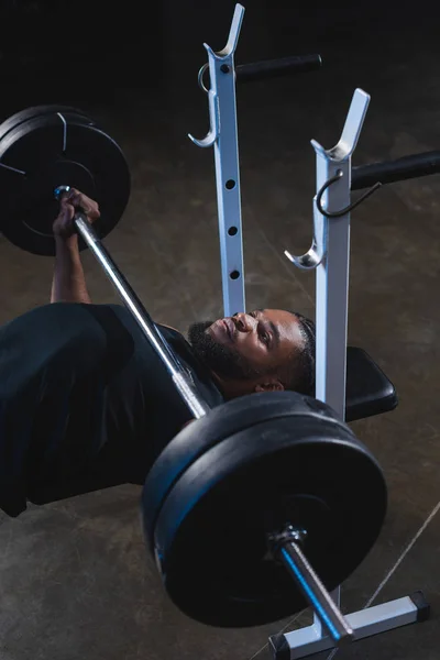 Vista ad alto angolo di uomo muscoloso afroamericano sollevamento bilanciere in palestra — Foto stock