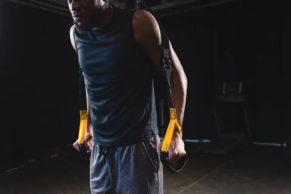 Tiro recortado de musculoso Africano americano desportista treinamento com alças de fitness — Fotografia de Stock
