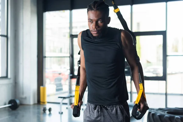 Muscular young african american sportsman exercising with resistance bands in gym — Stock Photo