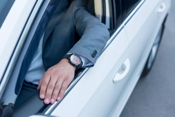 Tiro cortado de homem de negócios sentado no banco dos motoristas em carro — Fotografia de Stock