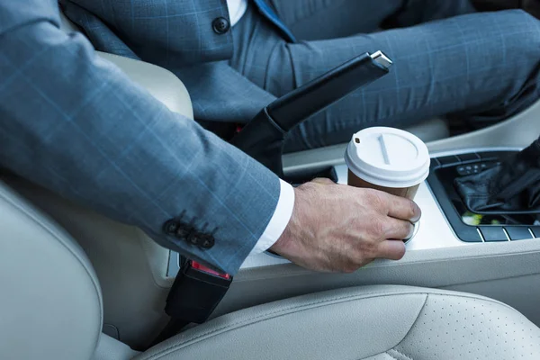 Recortado disparo de hombre de negocios tomando café para ir en coche - foto de stock