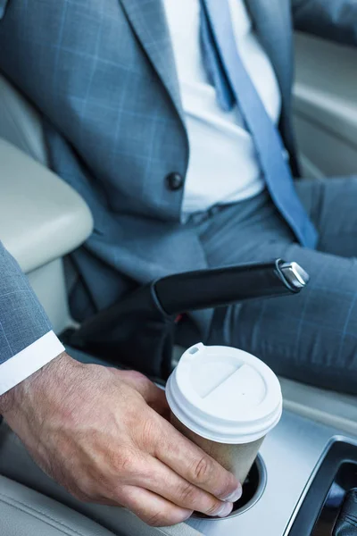 Обрезанный снимок бизнесмена, пьющего кофе в машине — стоковое фото