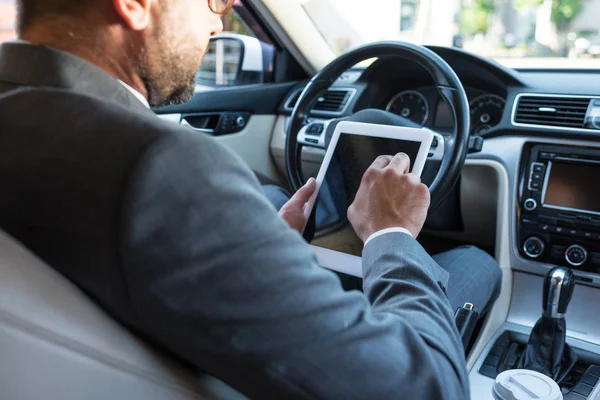 Частичный взгляд бизнесмена на использование планшета в автомобиле — стоковое фото
