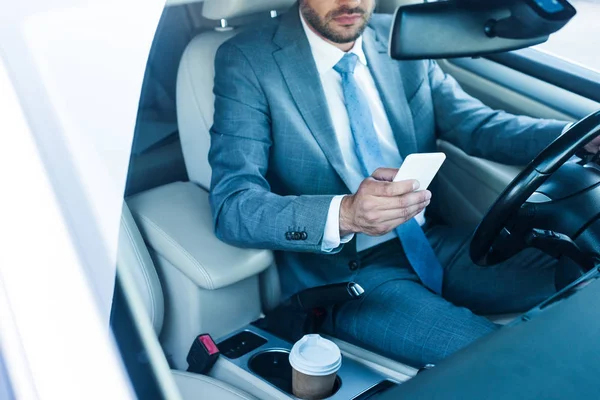 Partial view of businessman using smartphone in car — Stock Photo