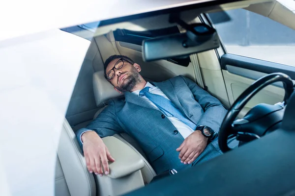 Stanco uomo d'affari in occhiali dormire in auto — Foto stock