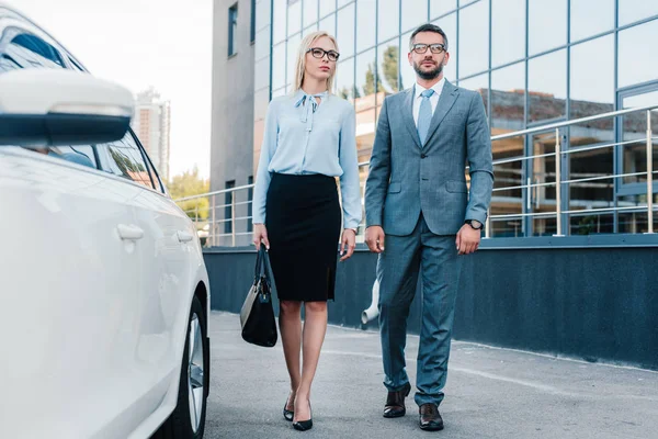 Pessoas de negócios em óculos andando de carro no estacionamento — Fotografia de Stock
