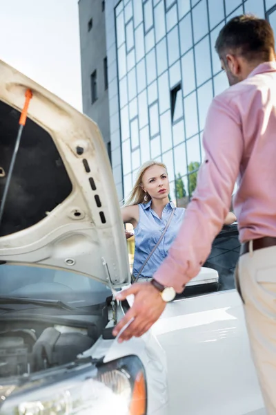 Couple having argument at broken car on street — Stock Photo