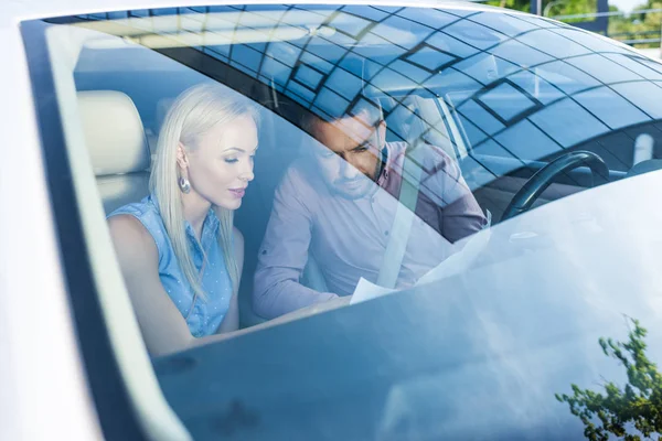 Casal procurando destino no mapa enquanto sentado em carro — Fotografia de Stock