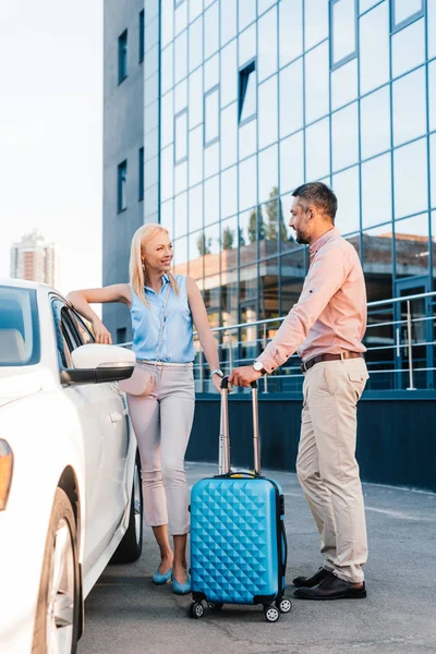 Mann und Frau mit Gepäck stehen am Auto auf Parkplatz — Stockfoto