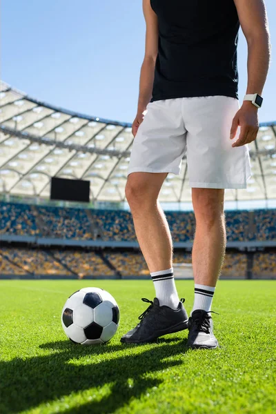 Cropped shot of soccer player standing with ball at modern sports stadium — Stock Photo