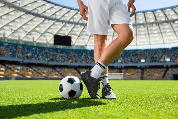 Cropped shot of soccer player standing with ball at sports stadium — Stock Photo