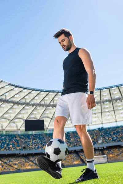 Bel giovane calciatore che si allena con la palla allo stadio sportivo — Foto stock