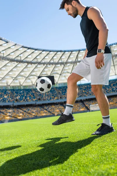 Giovane giocatore di calcio che rimbalza palla sulla gamba allo stadio sportivo — Foto stock