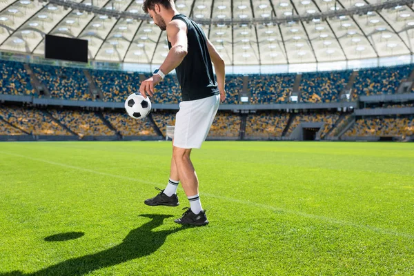 Bonito jovem jogador de futebol saltando bola na perna no estádio de esportes — Fotografia de Stock