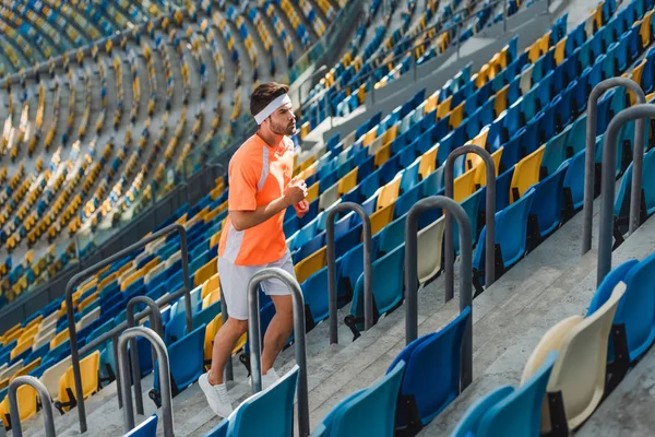 Atlético jovem jogging no andar de cima no estádio de esportes — Fotografia de Stock