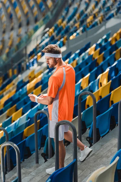Sportlicher junger Mann läuft Treppe am Sportstadion hinunter — Stockfoto