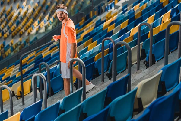Sportive young man walking downstairs on stairs at sports stadium — Stock Photo