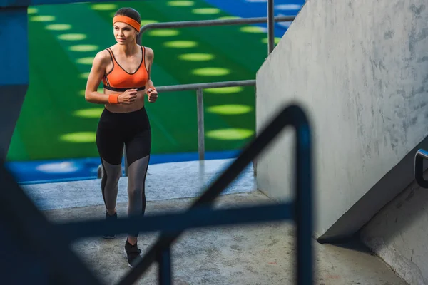 Vista de ángulo alto de hermosa mujer joven corriendo en el estadio de deportes - foto de stock