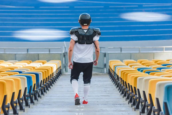 Vue arrière du footballeur américain sportif dans les escaliers du stade de sport — Photo de stock