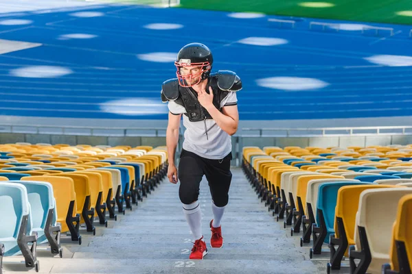 Apuesto joven jugador de fútbol americano va arriba en el estadio de deportes - foto de stock