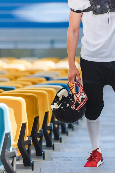 Обрезанный снимок американского футболиста, стоящего на лестнице на спортивном стадионе — стоковое фото