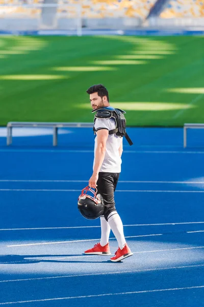 Молодой американский футболист, стоящий один на спортивном стадионе — стоковое фото