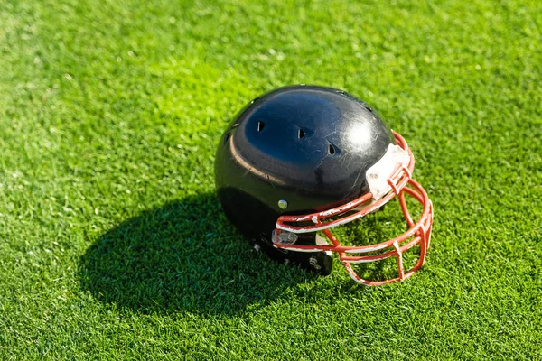 Высокий угол обзора футбольного шлема, лежащего на траве — стоковое фото