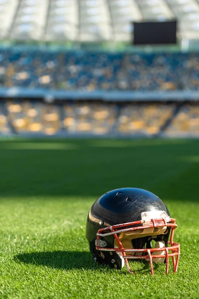Nahaufnahme eines amerikanischen Fußballhelms, der auf dem Rasen des Stadions liegt — Stockfoto