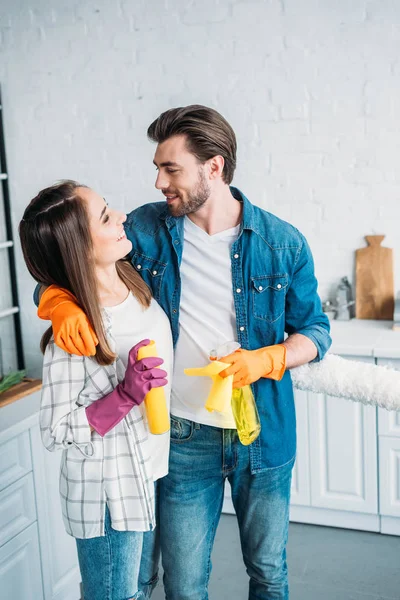 Abraço casal feliz durante a limpeza da cozinha — Fotografia de Stock