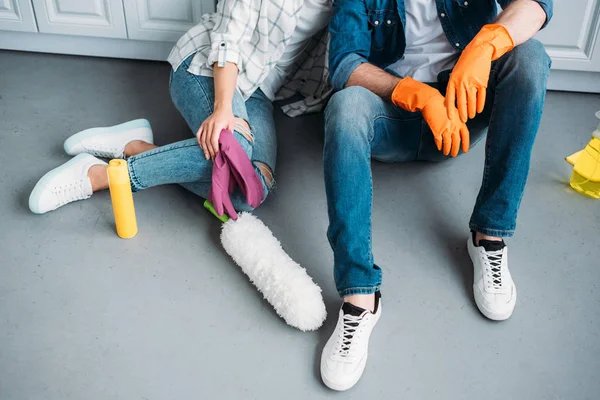 Imagen recortada de pareja sentada en el suelo después de la limpieza en la cocina — Stock Photo