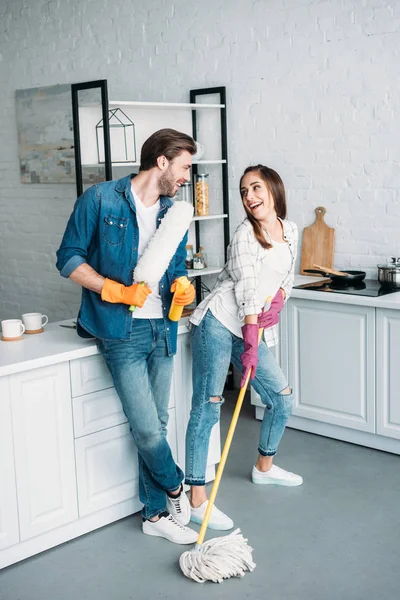 Petite amie posant avec la serpillière tout en nettoyant dans la cuisine — Photo de stock